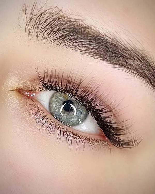 Natürliche Wimpernverlängerung an einem grünen Auge